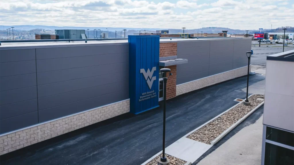 Exterior view of a building with a WV logo and “WVU Baseball Biomechanics and Performance Center” signage.