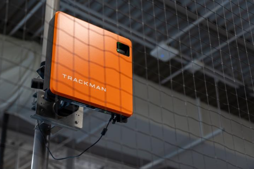 A TrackMan device is mounted inside an indoor baseball training facility.